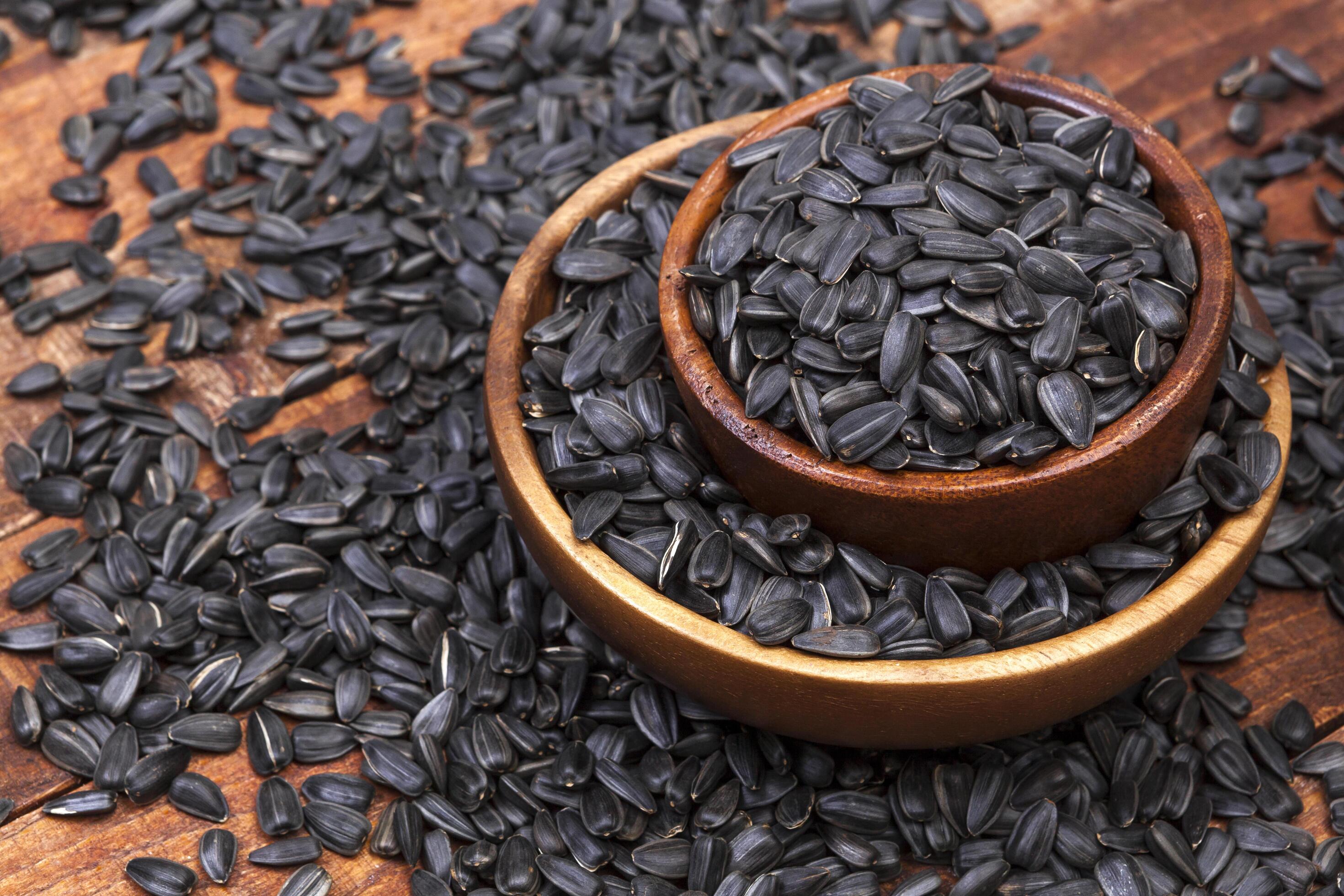 Sunflower seeds in bowl on wooden background Stock Free