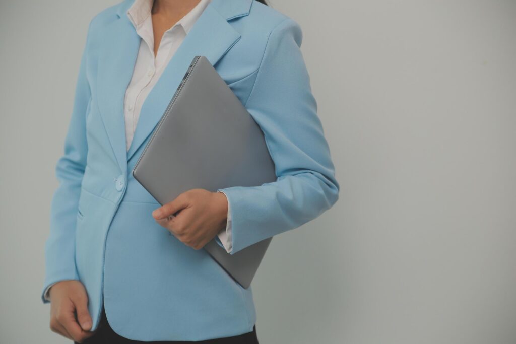 Portrait of a happy asian businesswoman working on laptop computer isolated over white background Stock Free