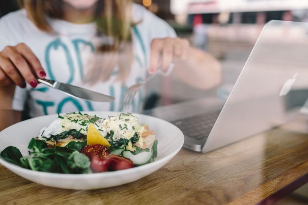 Close up image of young woman eating classic breakfast at restaurant Stock Free