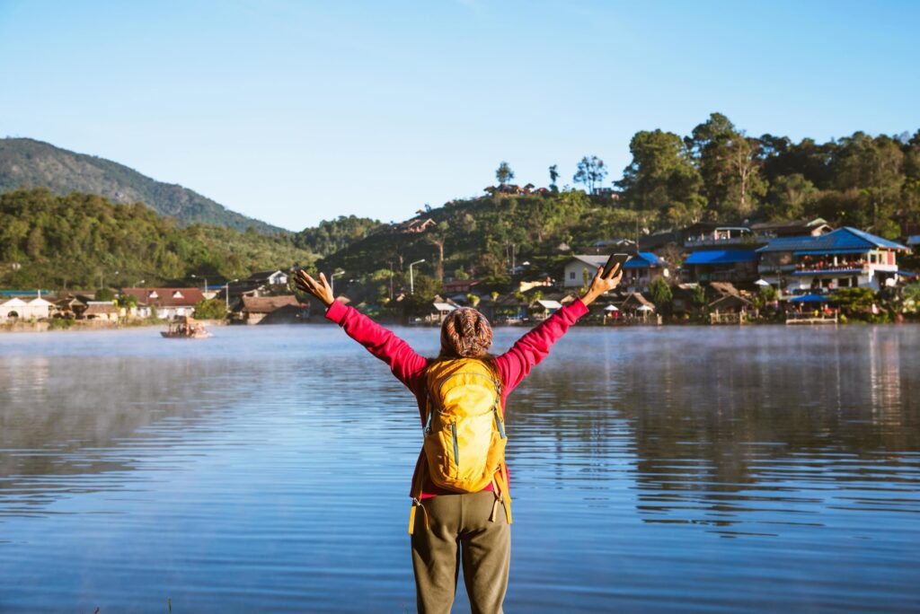 The woman standing near the lake, she was smiling, enjoying and enjoying the natural beauty of the mist. Stock Free