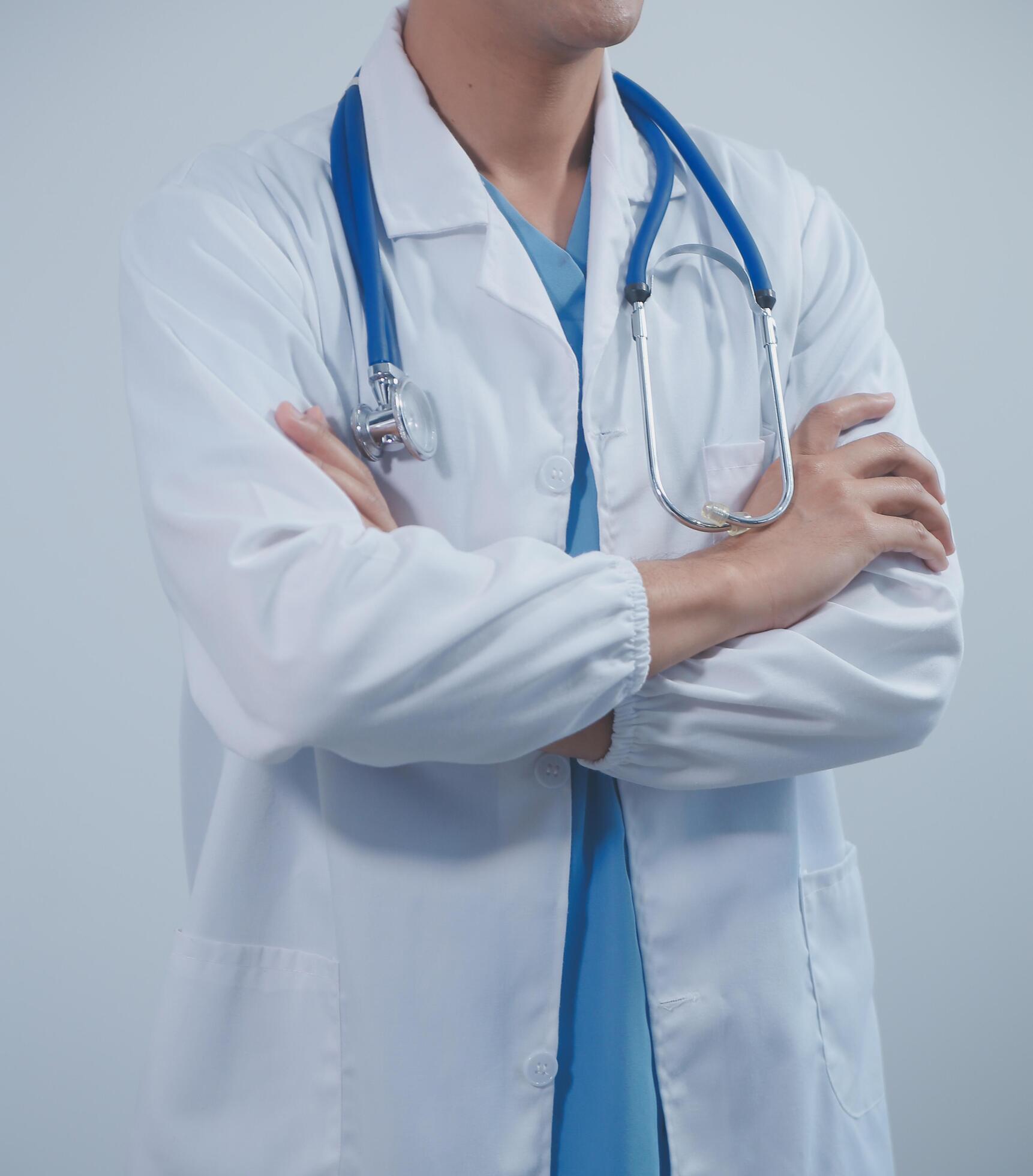 Mature male doctor with tablet pc is giving presentation. Blurred background indoors. Stock Free