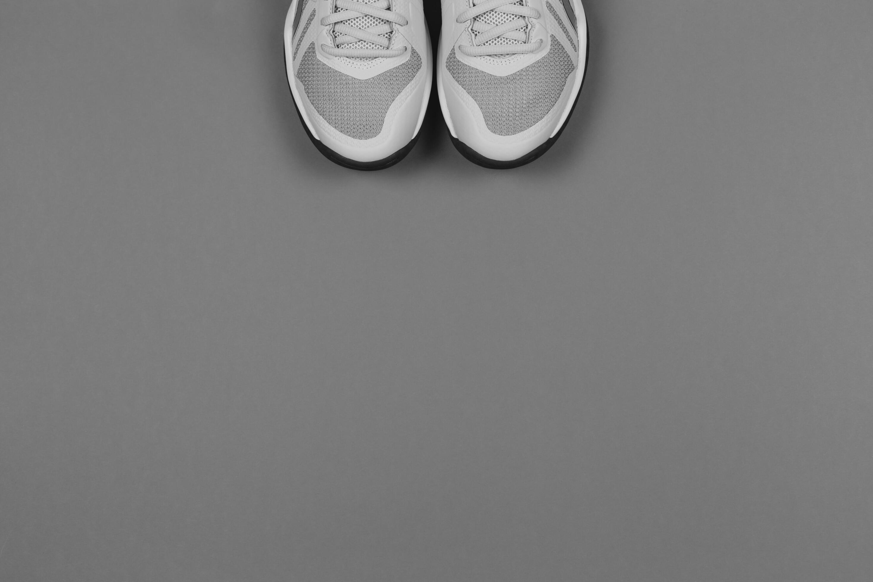 Light grey sneakers on the grey background. Concept for healthy lifestyle and everyday training. Stock Free