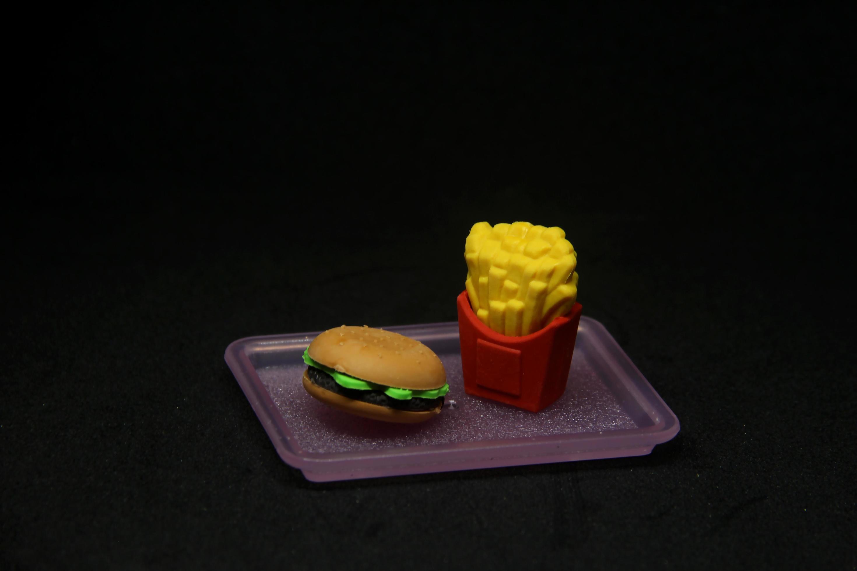 Hamburger and fries shaped eraser. School or office stationary tool supplies with junk food shape. isolated photo on dark black background. Stock Free