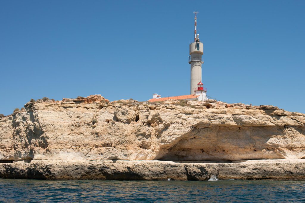 Coast of Portugal. Cliffs at Algarve, huge communication antenna and lighthouse. Stock Free