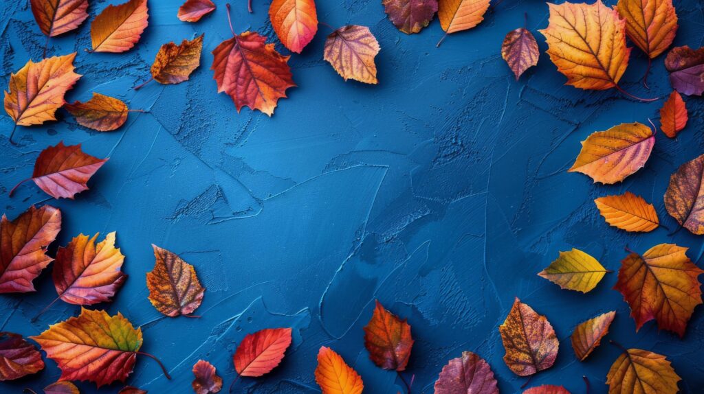 
									Colorful autumn leaves scattered on a vibrant blue background Stock Free