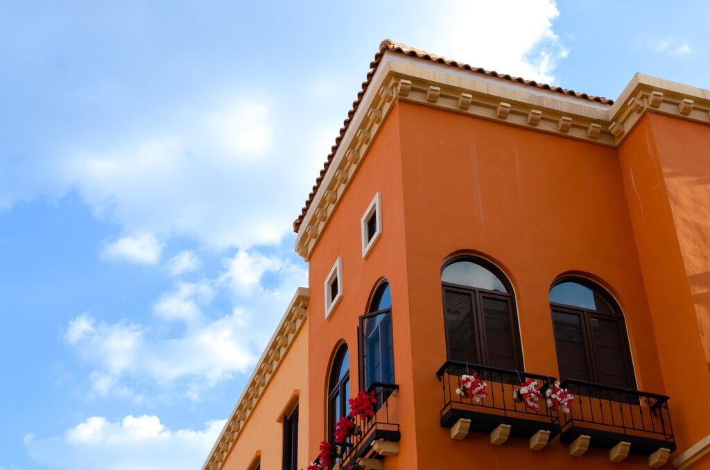 Colorful orange building with black and white window frames. Look up to the blue sky. Stock Free