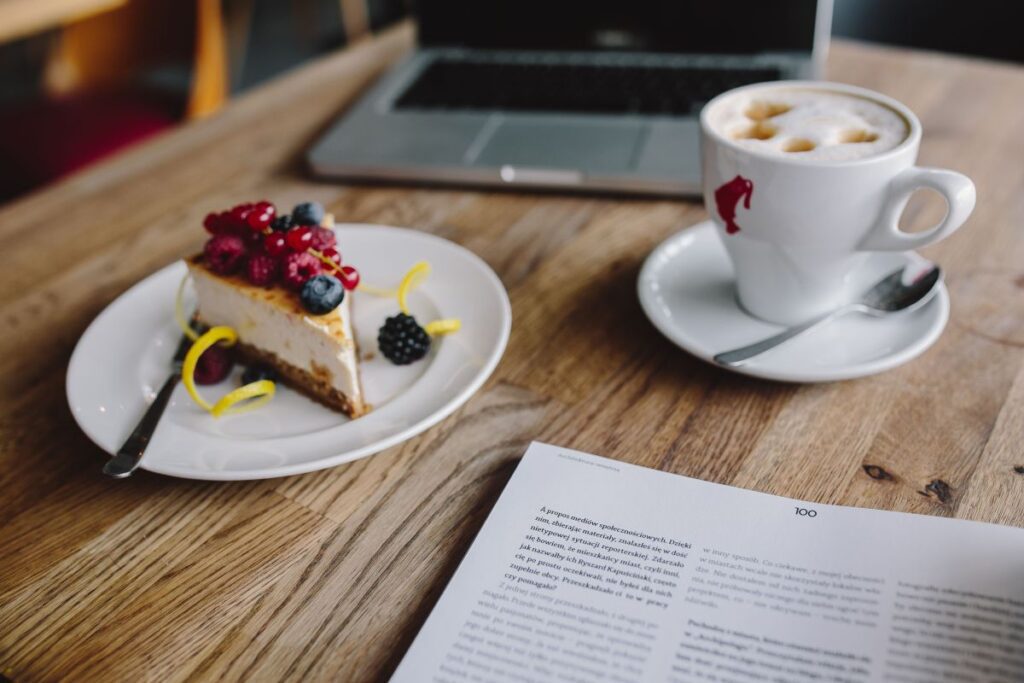 Working in a restaurant: Macbook, Cheese Cake and Cup of Coffee Stock Free