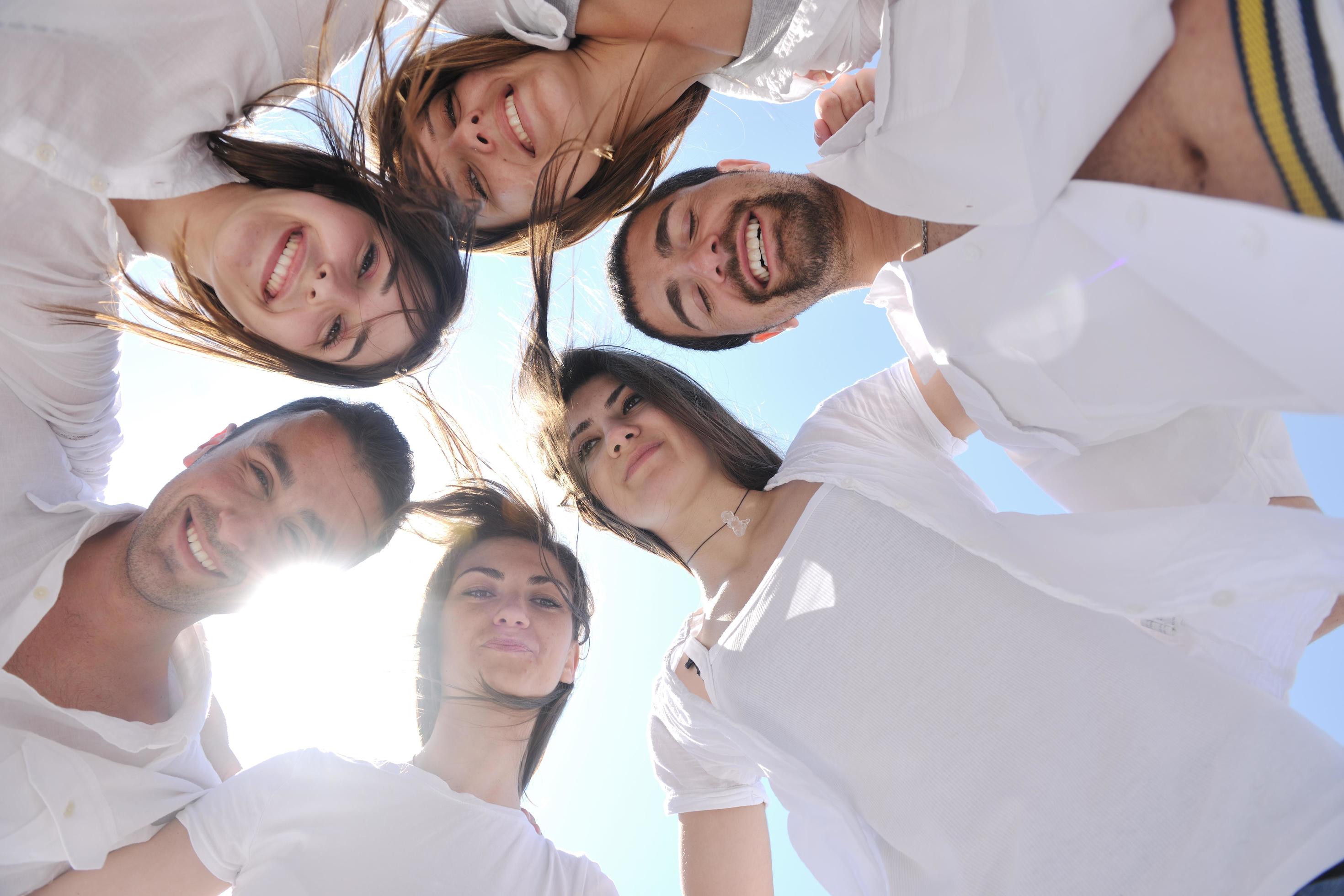 Group of happy young people in circle at beach Stock Free