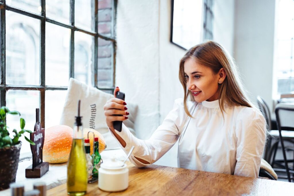 Pretty blonde woman sitting in the cafe Stock Free