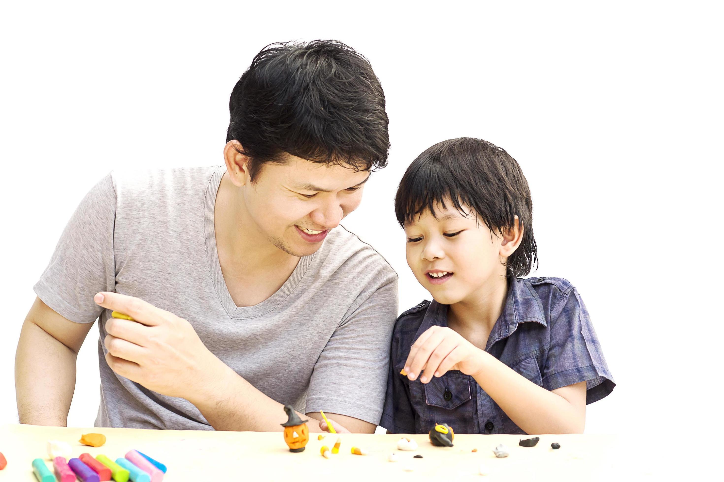 Father is playing Halloween clay with his son over white background Stock Free