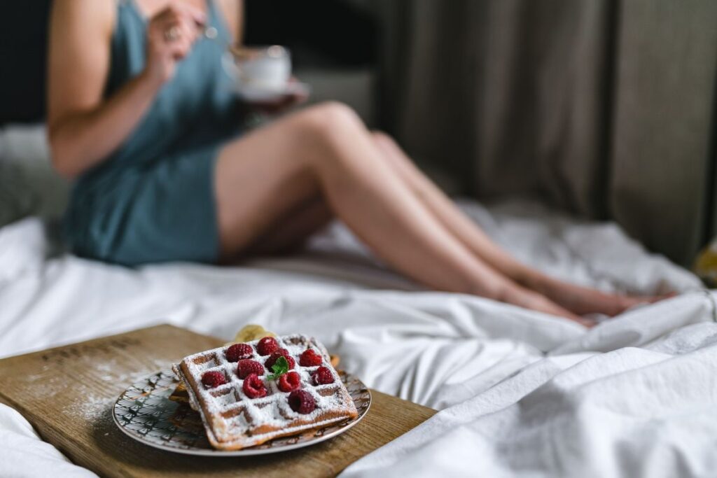 Breakfast in bed – waffles with raspberries and cup of coffee on the tray Stock Free