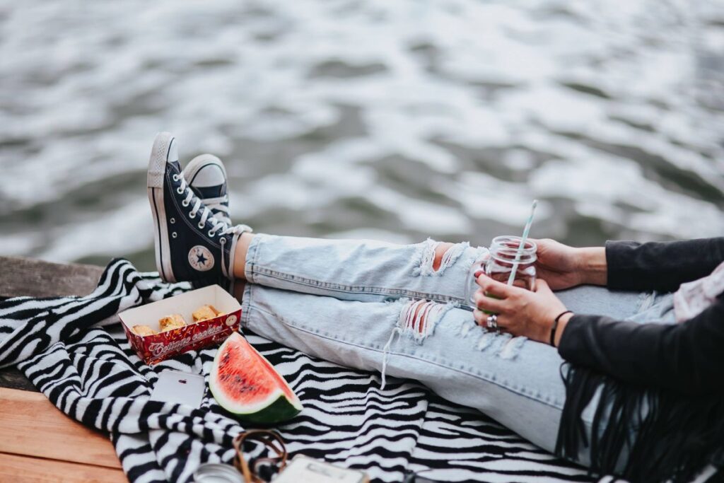 Blonde woman having a healthy snack at the wooden pier Stock Free