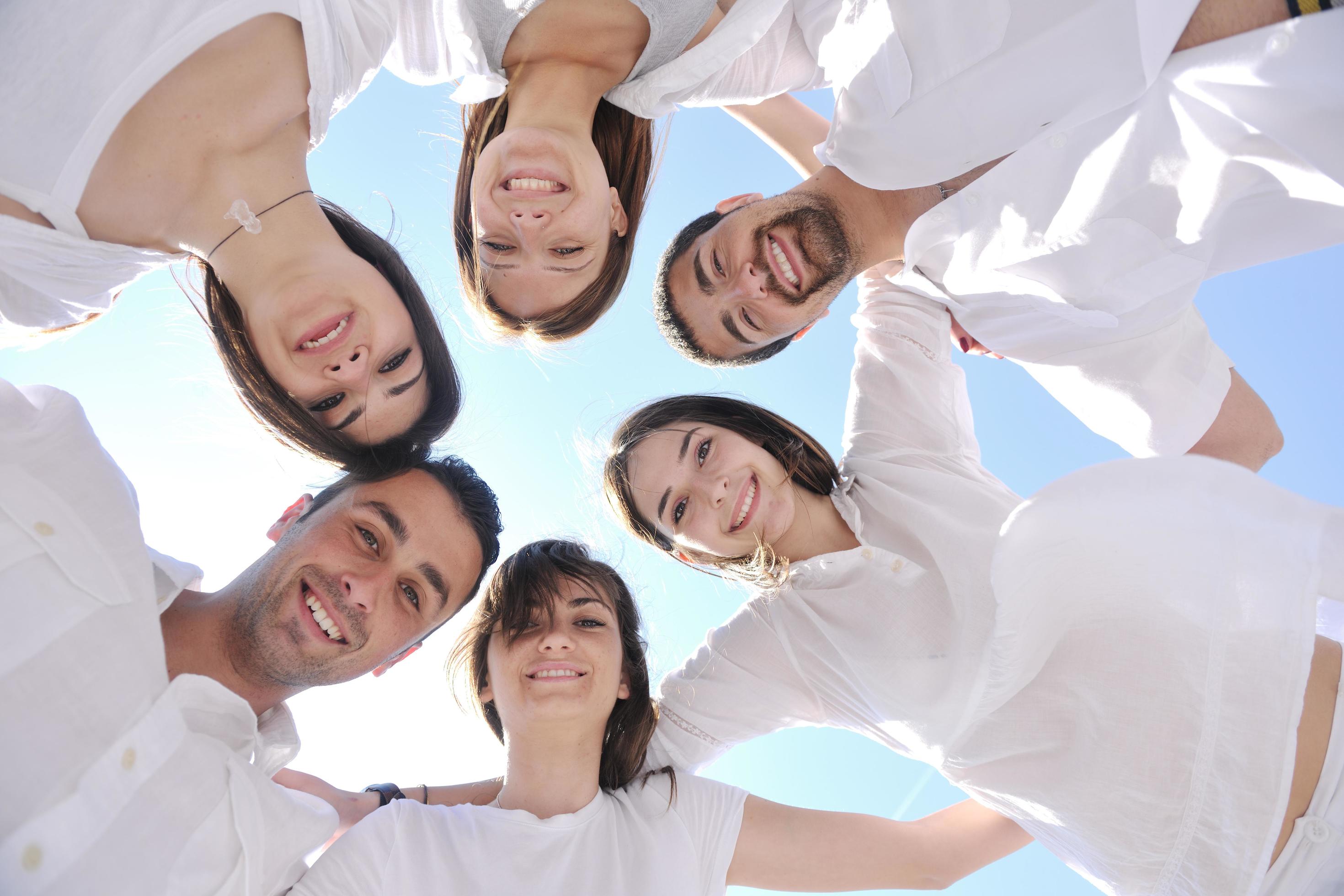 Group of happy young people in circle at beach Stock Free