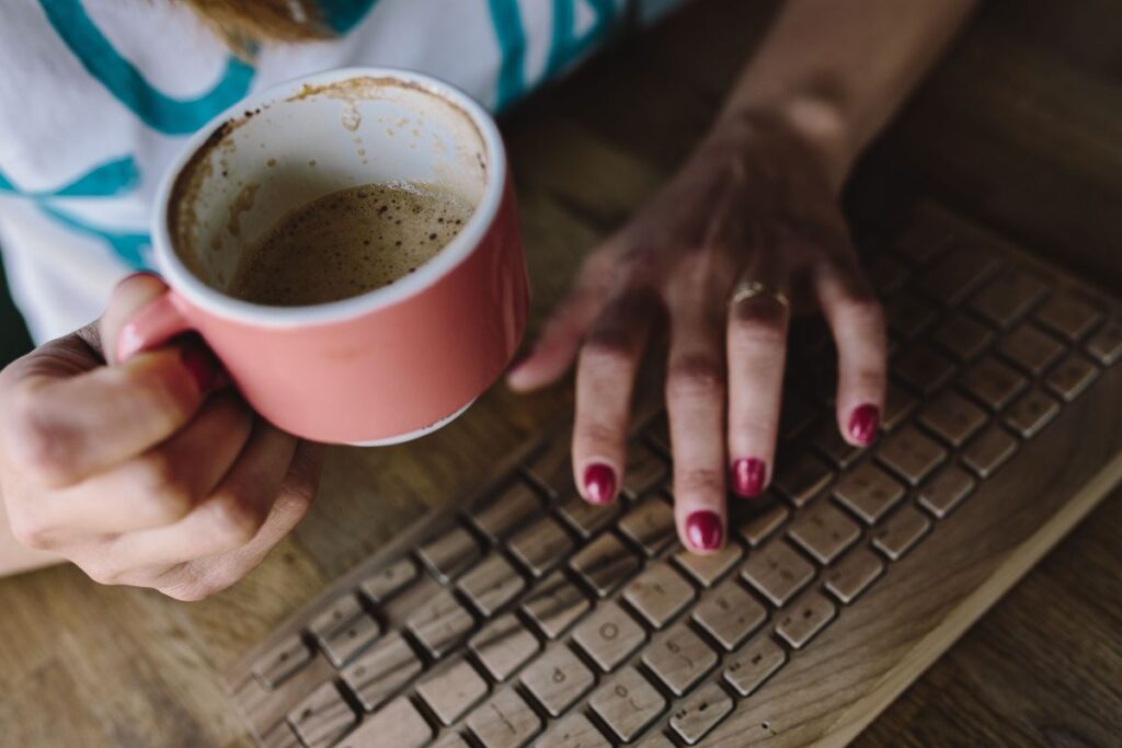 Closeup of female hands typing text on a wireless wooden keyboard Stock Free