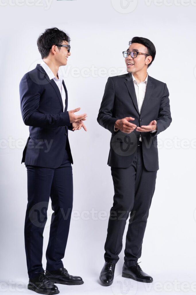 Two Asian businessmen walking on white background Pro Photo