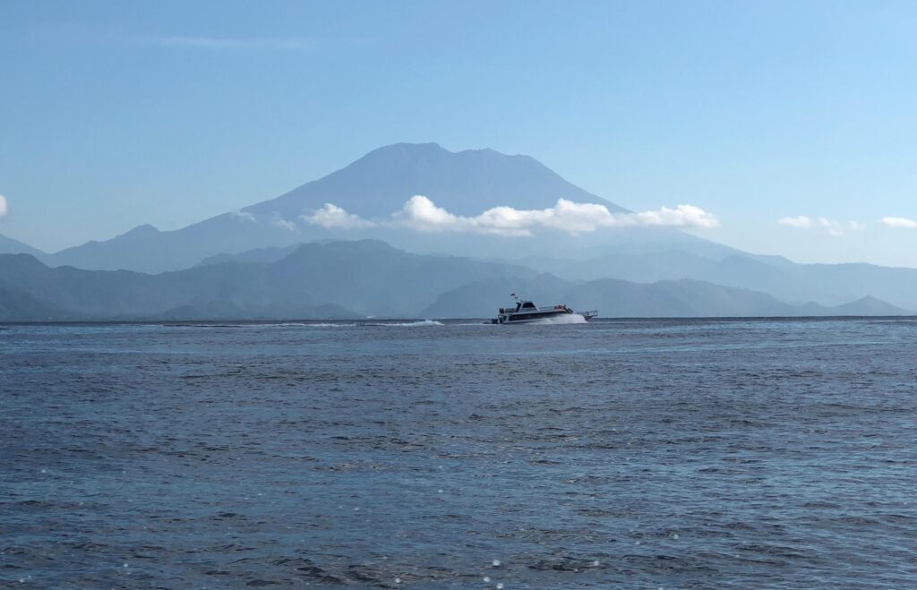 Speed boat running on the sea with mountain background. Stock Free