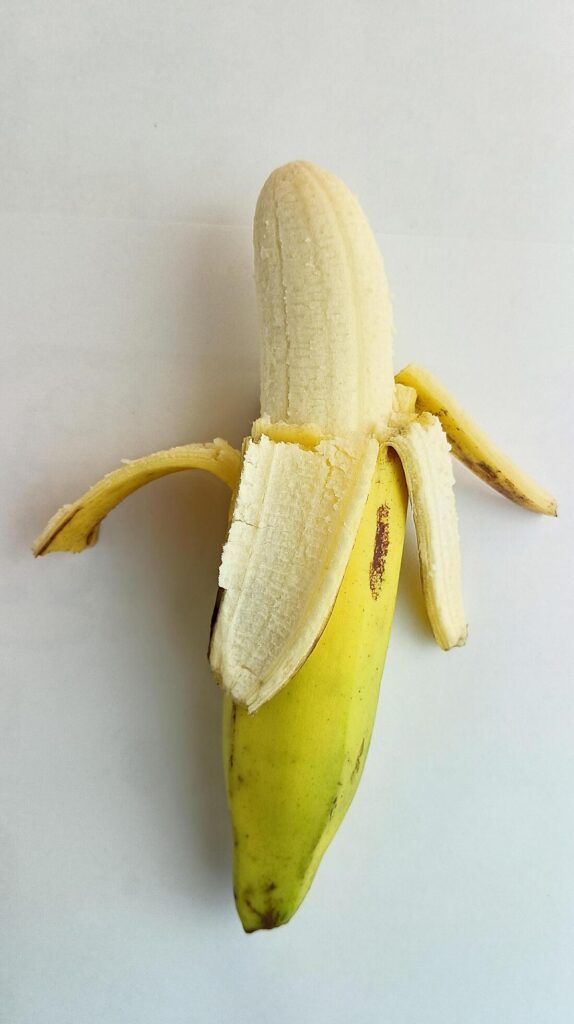 opened yellow banana on a white background Stock Free