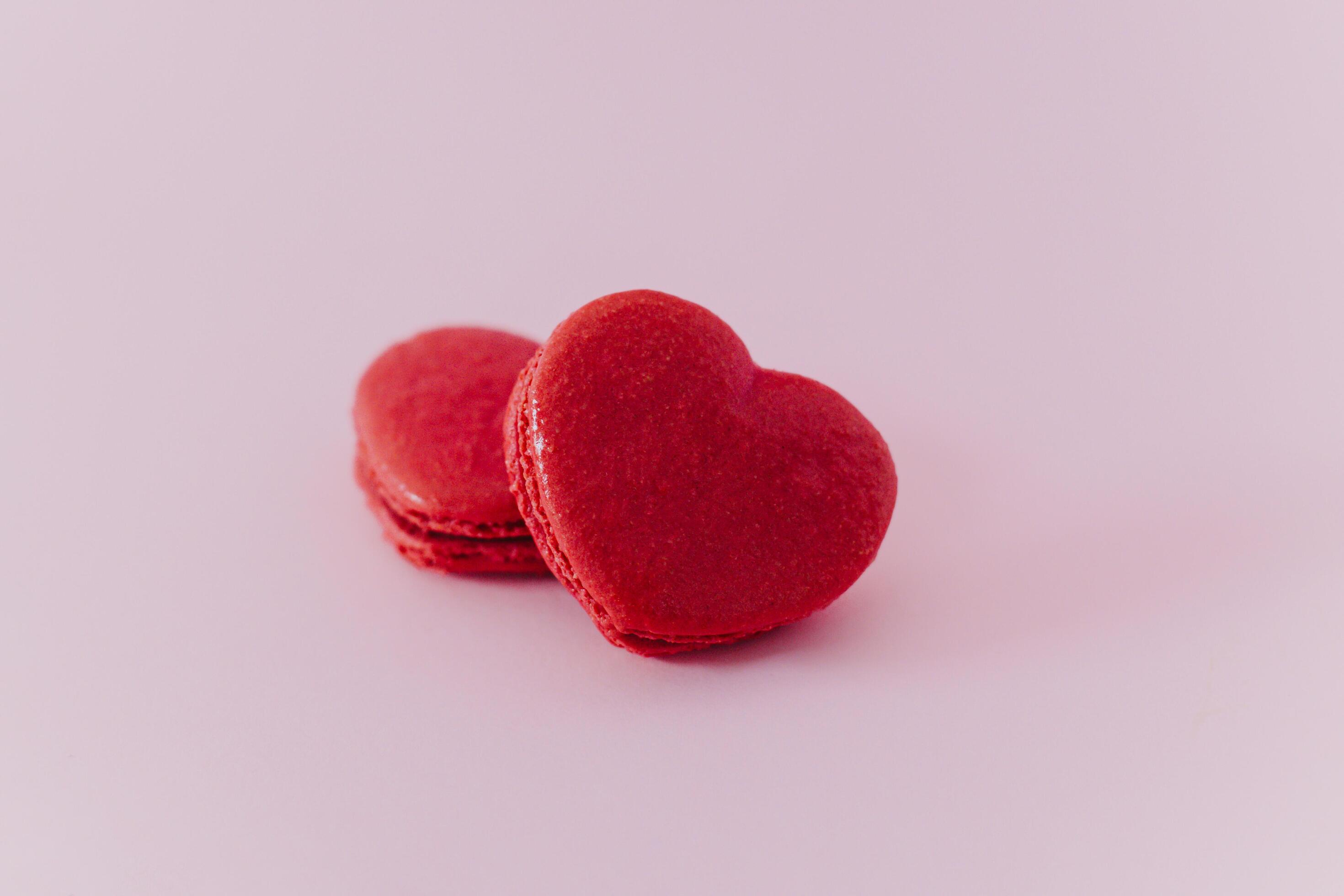 Pink heart shaped french macarons on a pink pastel background. Concept for Valentine’s day. Stock Free