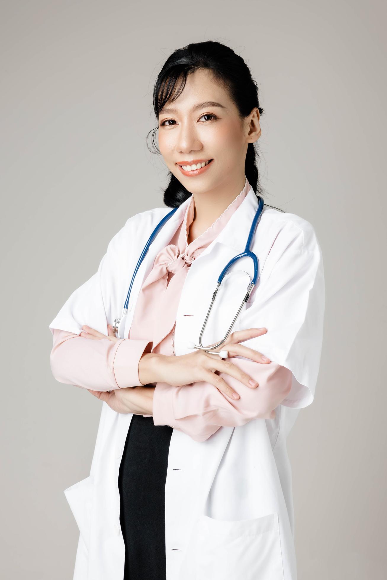 Portrait of an attractive young female doctor in white coat. Stock Free