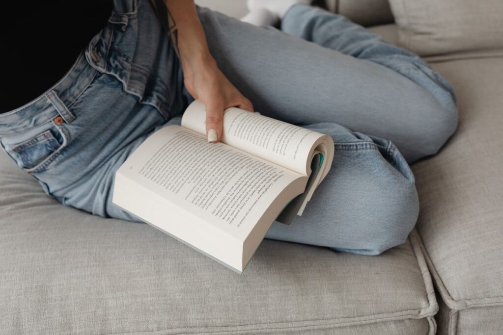 Woman in light-colored jeans with books Stock Free