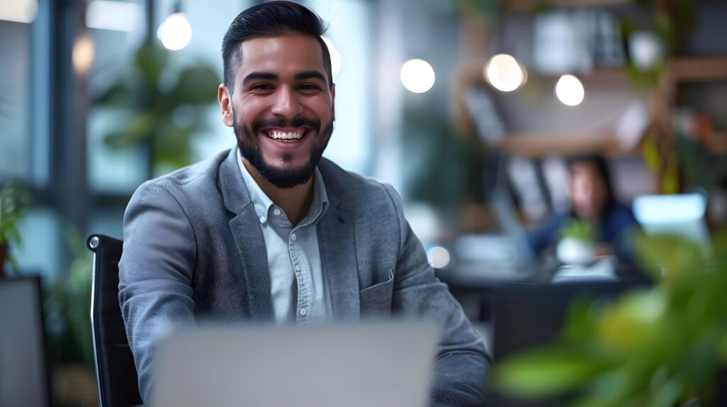 Smiling Young Professional Business Manager Working on Laptop in Modern Office Setting Stock Free