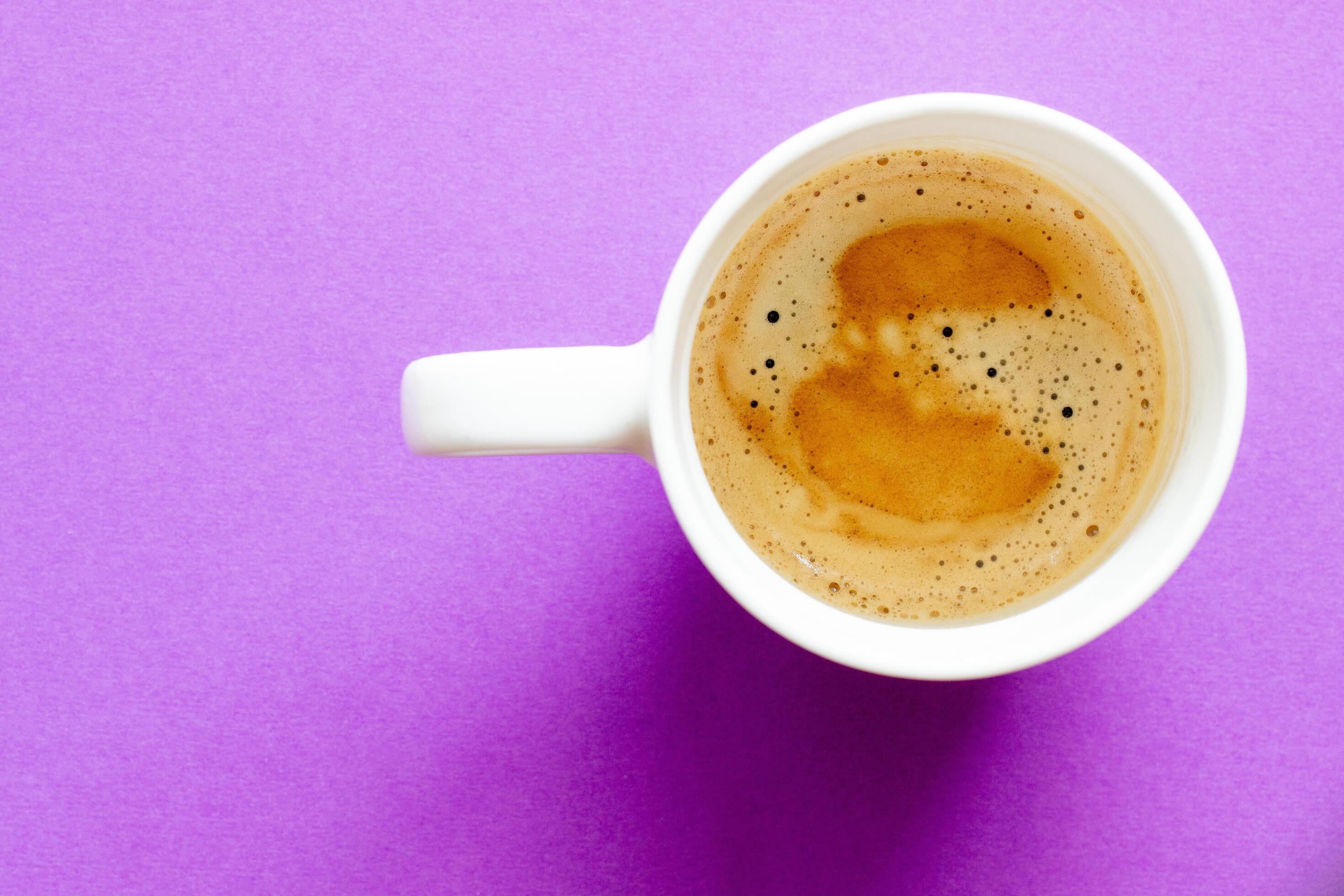 a cup of coffee on a purple background Stock Free