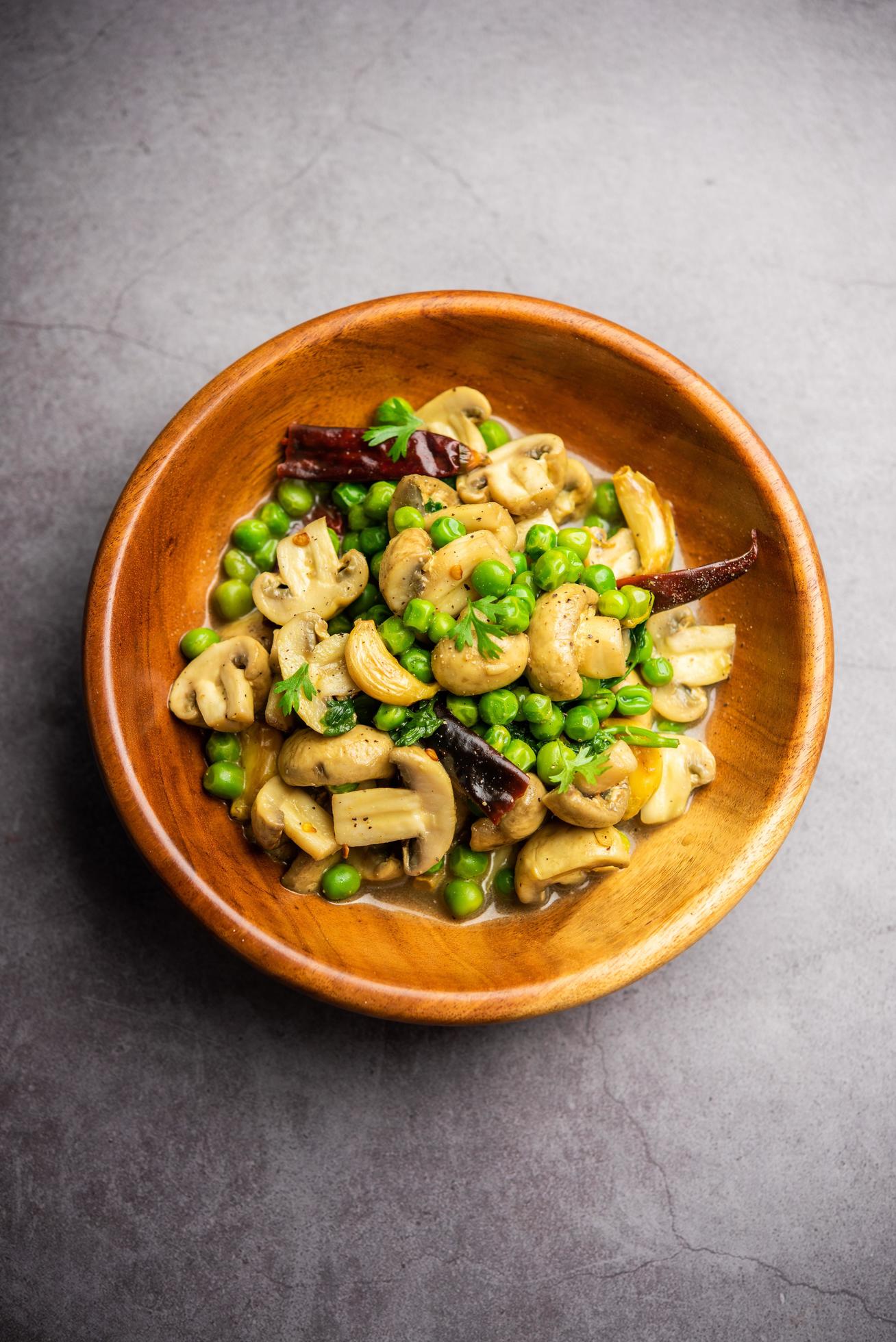 Mushroom and Pea Curry with Roasted Garlic, Indian food served in a bowl Stock Free