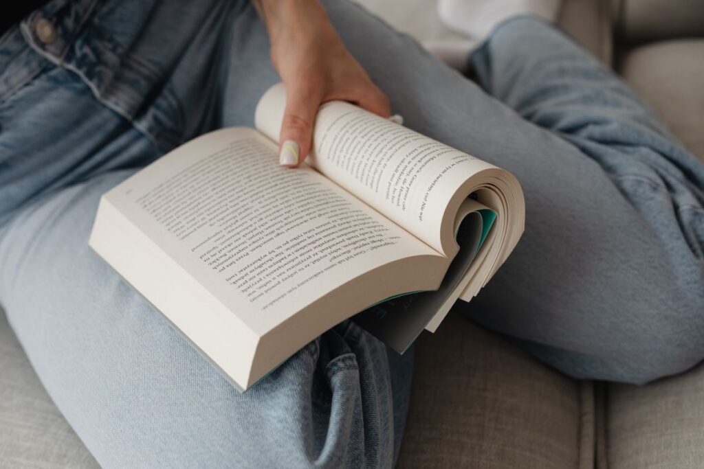 Woman in light-colored jeans with books Stock Free