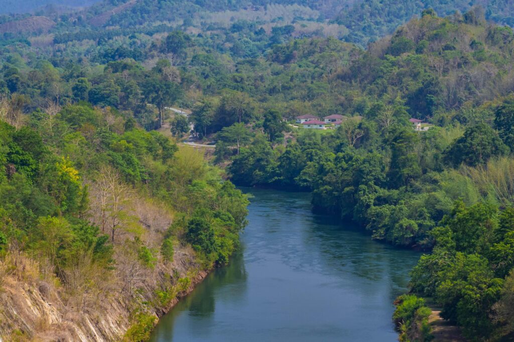 An aerial view of the dam-caused canal in Thailand’s national park, with a mountain the background. Bird eye view. Stock Free