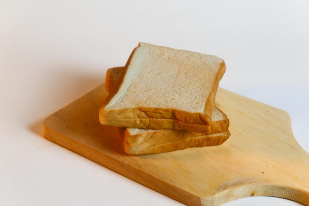 photography of bread on a wooden cutting board on a white background Stock Free