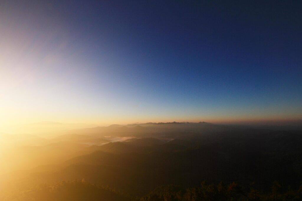 Beautiful golden natural sunlight and twiligh of sunrise shining to in the mist on valley of mountain in Thailand Stock Free