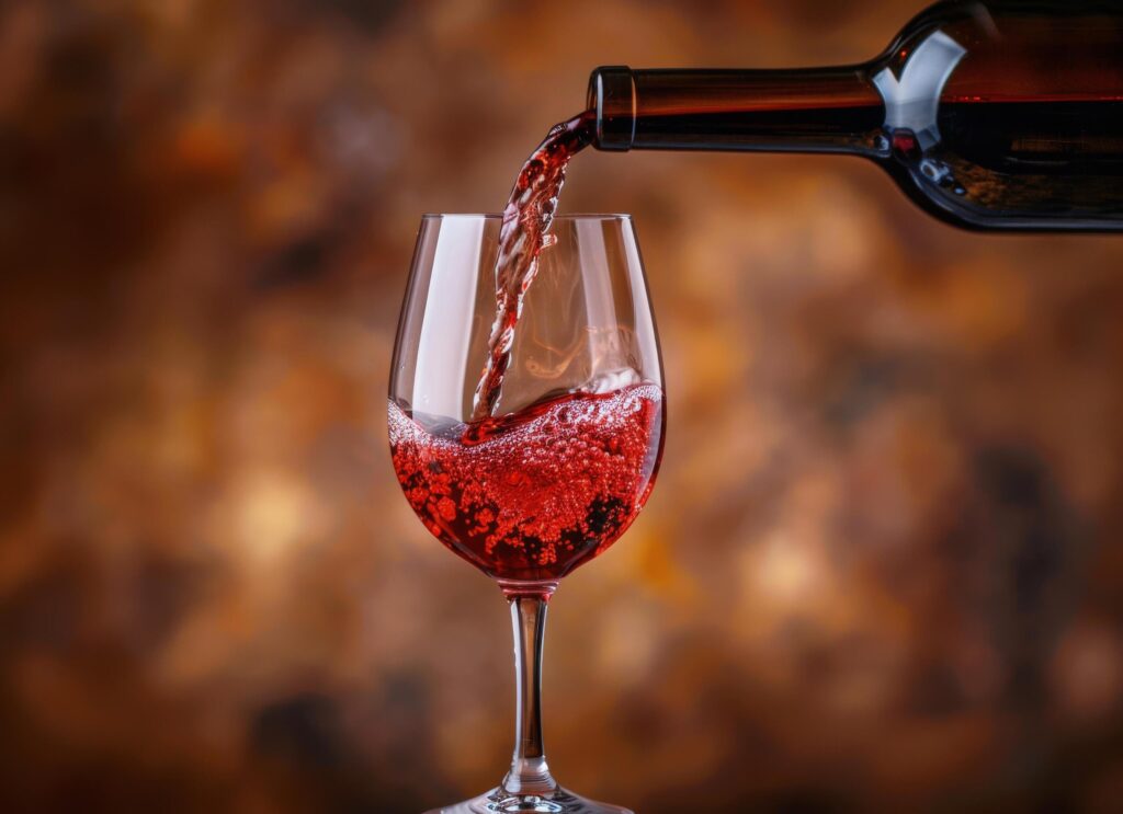 Red Wine Pouring Into Glass Against a Warm Background Stock Free