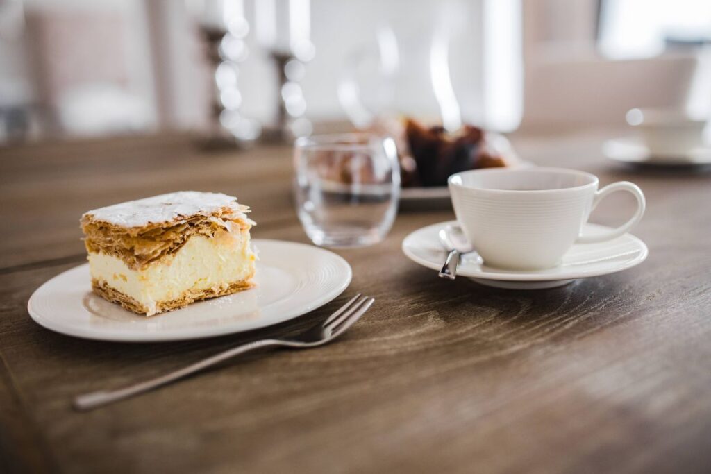 Sweet dessert with cream and a cup of coffee on a table Stock Free