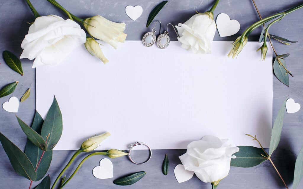 Blank paper copy space. Frame with flowers. Silk ribbon. Gray background. Simple bouquet. Greeting card. Stock Free