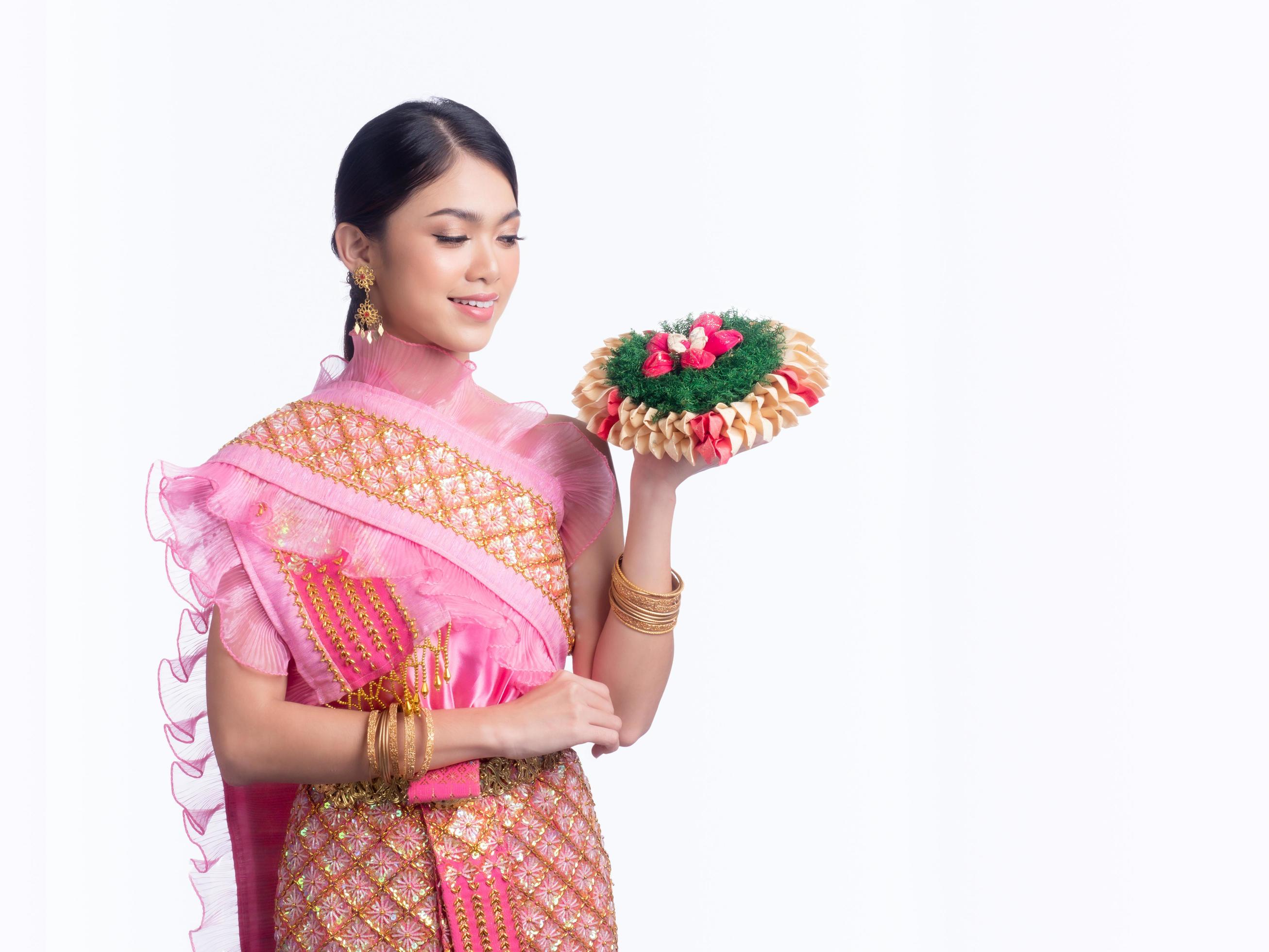 Attractive Thai woman dressed in traditional Thai clothes holds a flower basket Stock Free