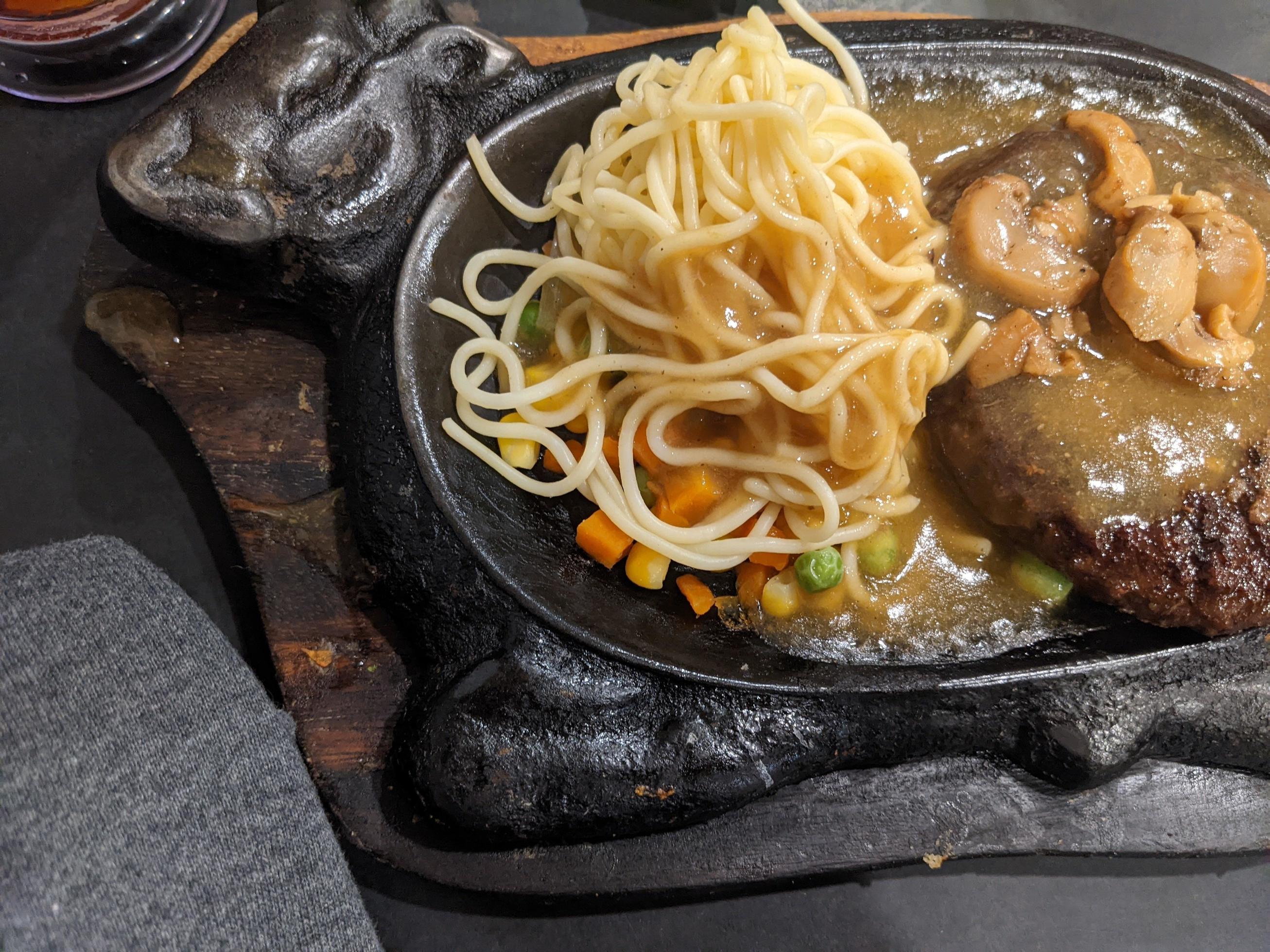 Extra beef steak with noodles and mushroom sauce. The photo is suitable to use for food background, poster and food content media. Stock Free