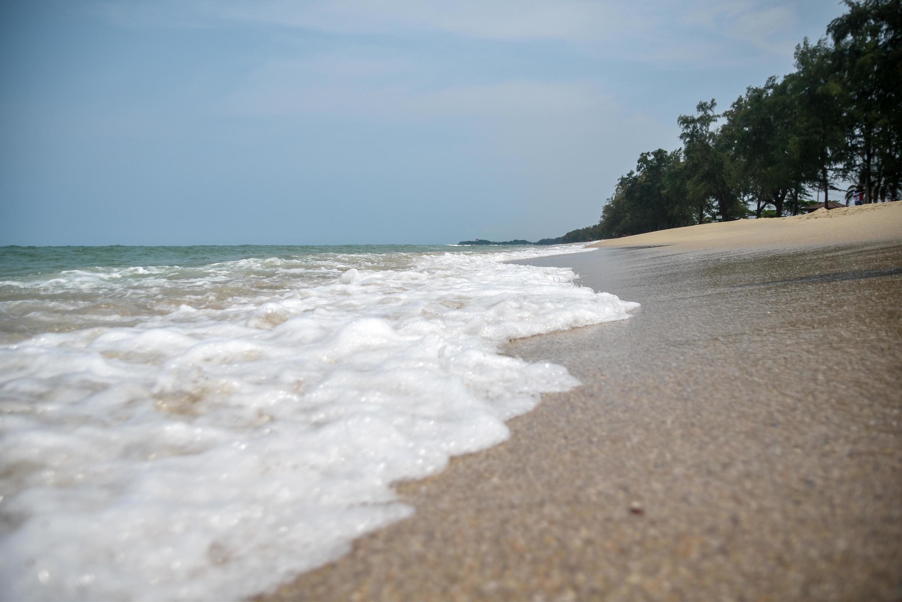 Wide angle shot of sea water hitting the beach, white sponge of the sea, summer nature background image concept. Stock Free