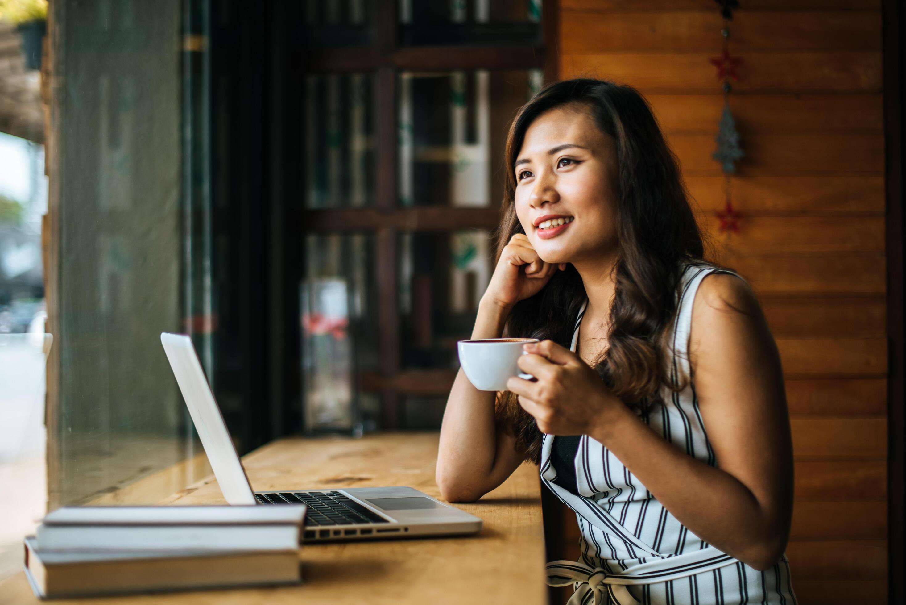 Beautiful woman working with laptop computer at coffee shop cafe Stock Free