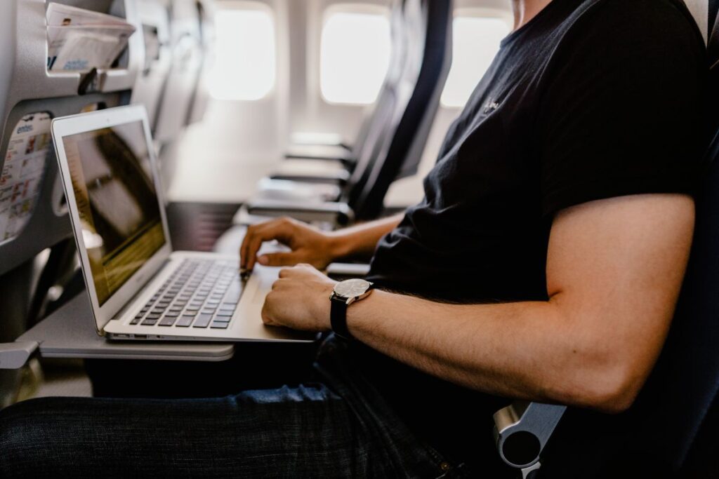 Unrecognizable man with notebook sitting inside an airplane Stock Free