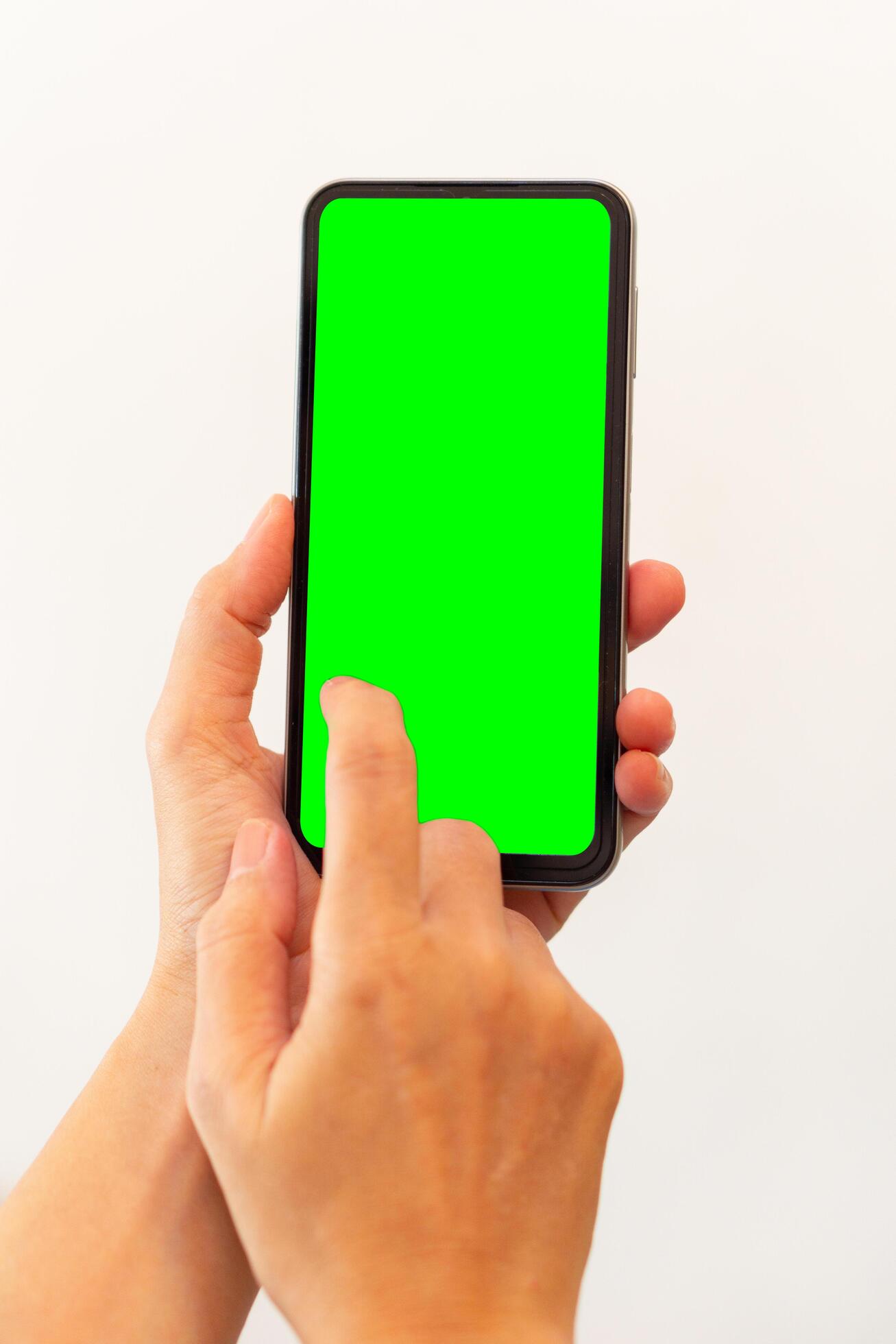 women hand holding smart mobile phone with blank green screen on isolated white background Stock Free