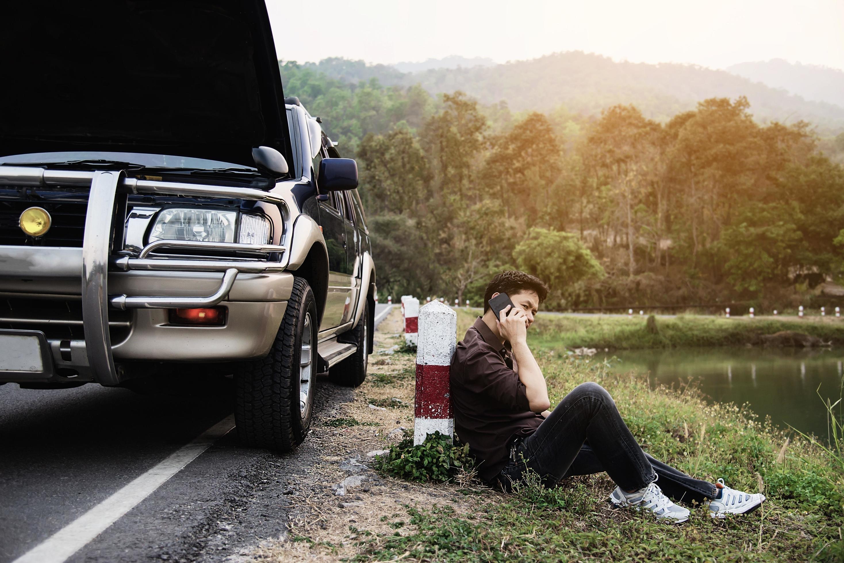 Man try to fix a car engine problem on a local road Chiang mai Thailand – people with car problem transportation concept Stock Free