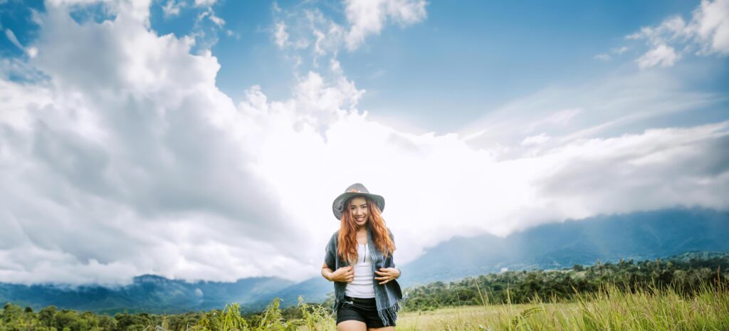 Asian women travel relax in the holiday. on a green pasture. Stock Free