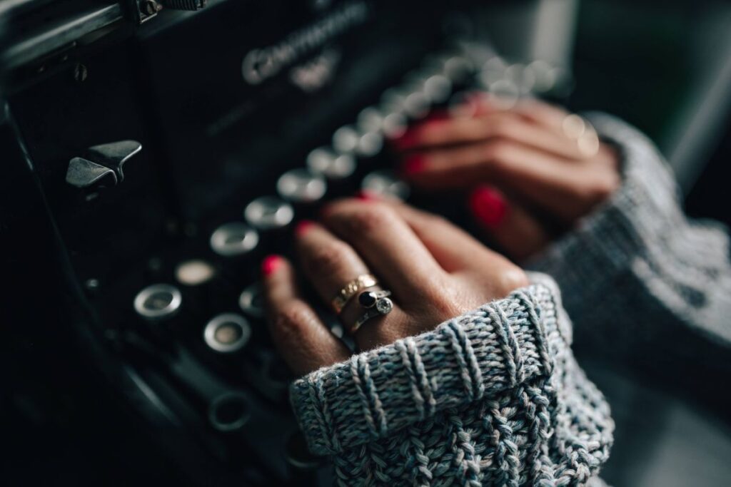 Woman typing on an old typewriter Stock Free