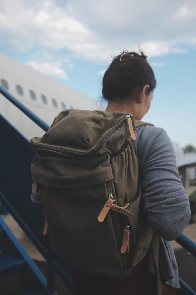 Happy attractive asian woman traveler with backpack at the modern airport terminal, copy space, Tourist journey trip concept Stock Free