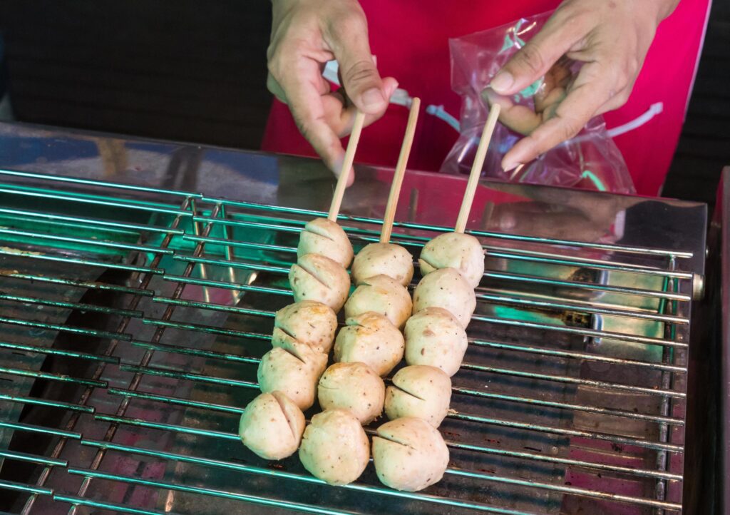 grill meatball on steel grating, a street food market Stock Free