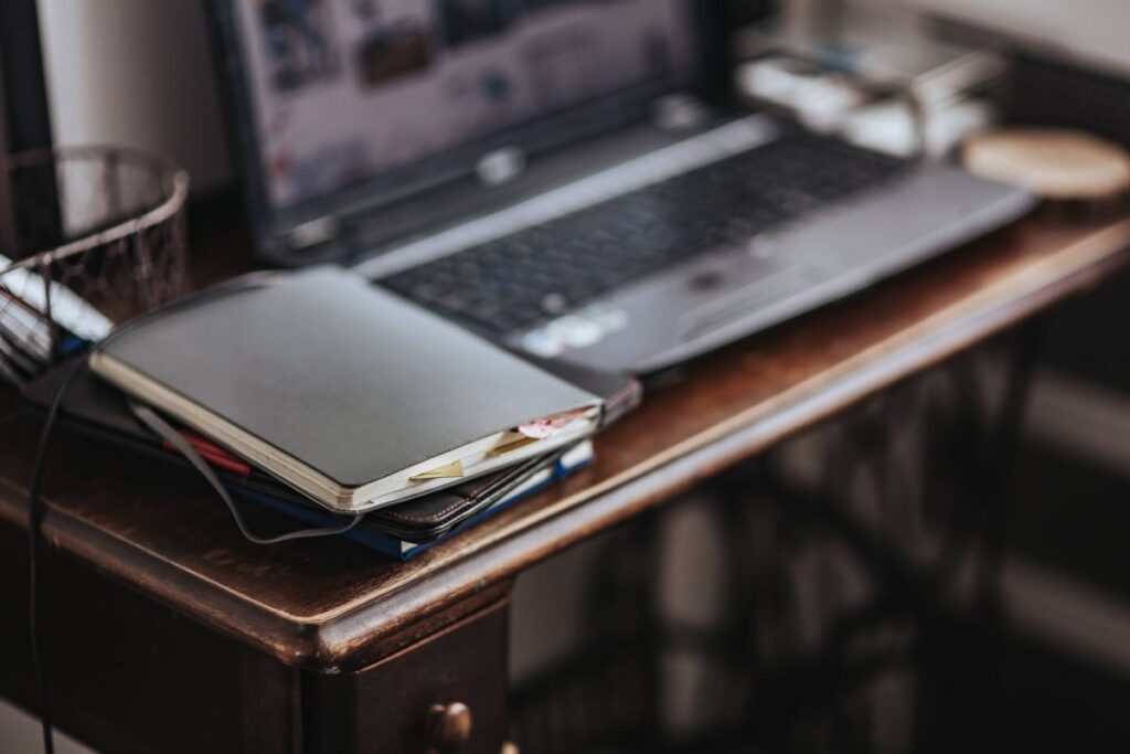 Workplace with a laptop and a notebook on a desk Stock Free