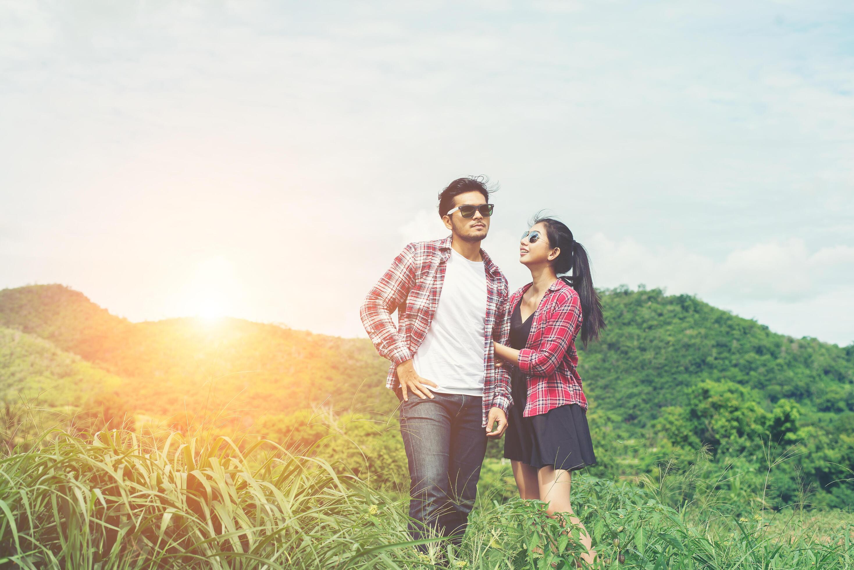 Young hipster couple holding hands walking on the meadow relaxing and natural atmosphere is very natural. Stock Free