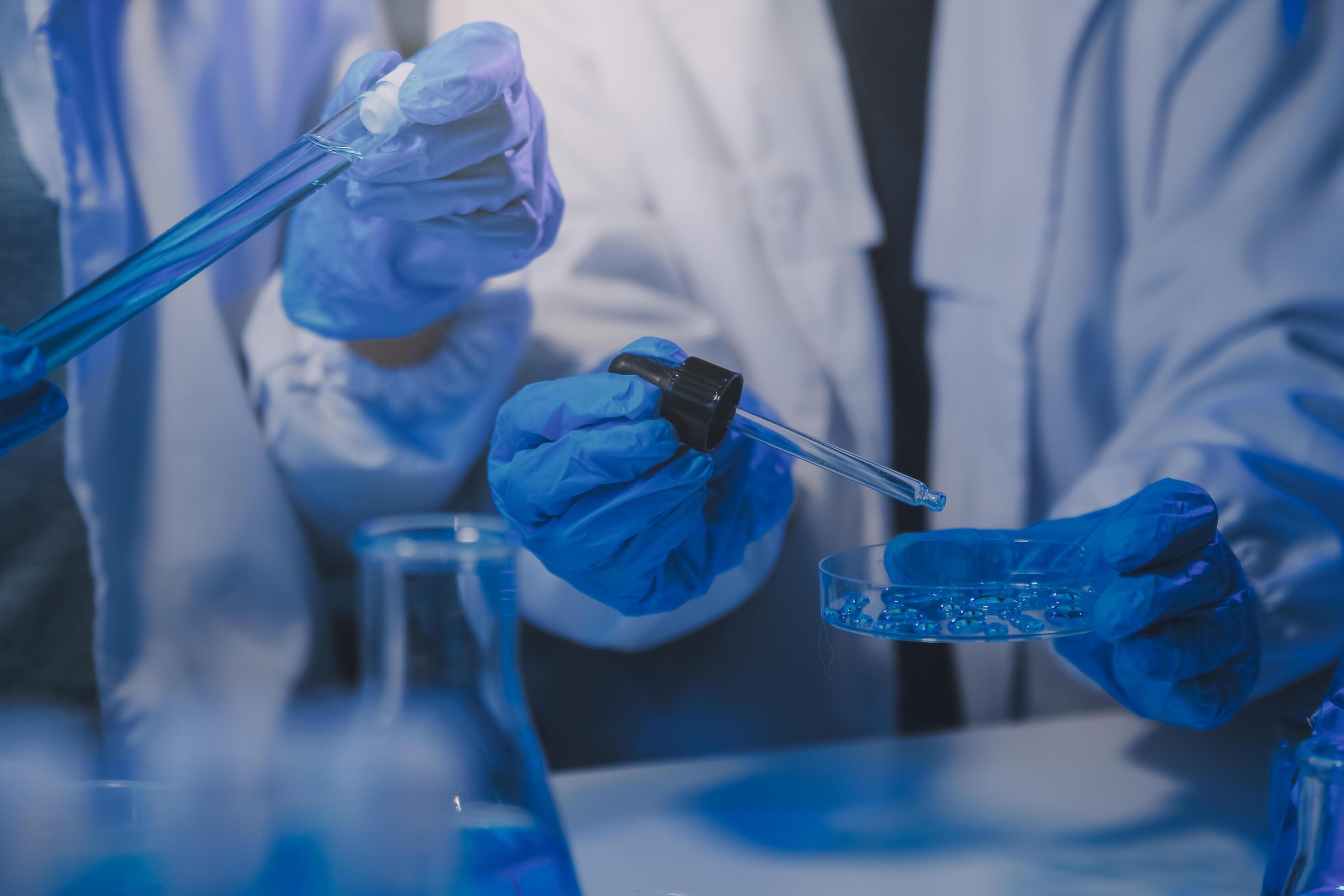 chemist,scientist hand dropping chemical liquid into test tube, science research and development concept Stock Free