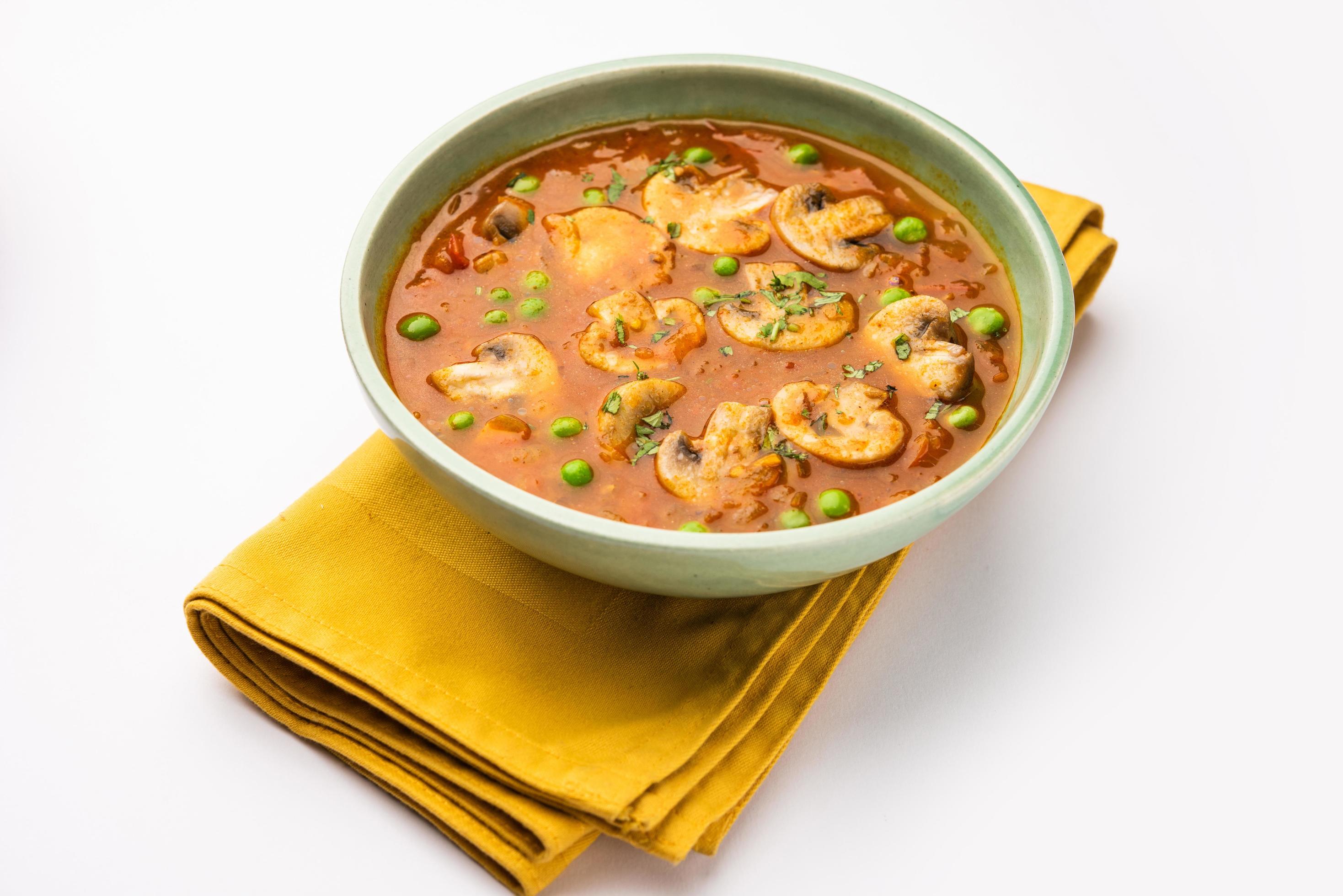 Mushroom and Pea Curry with Roasted Garlic, Indian food served in a bowl Stock Free