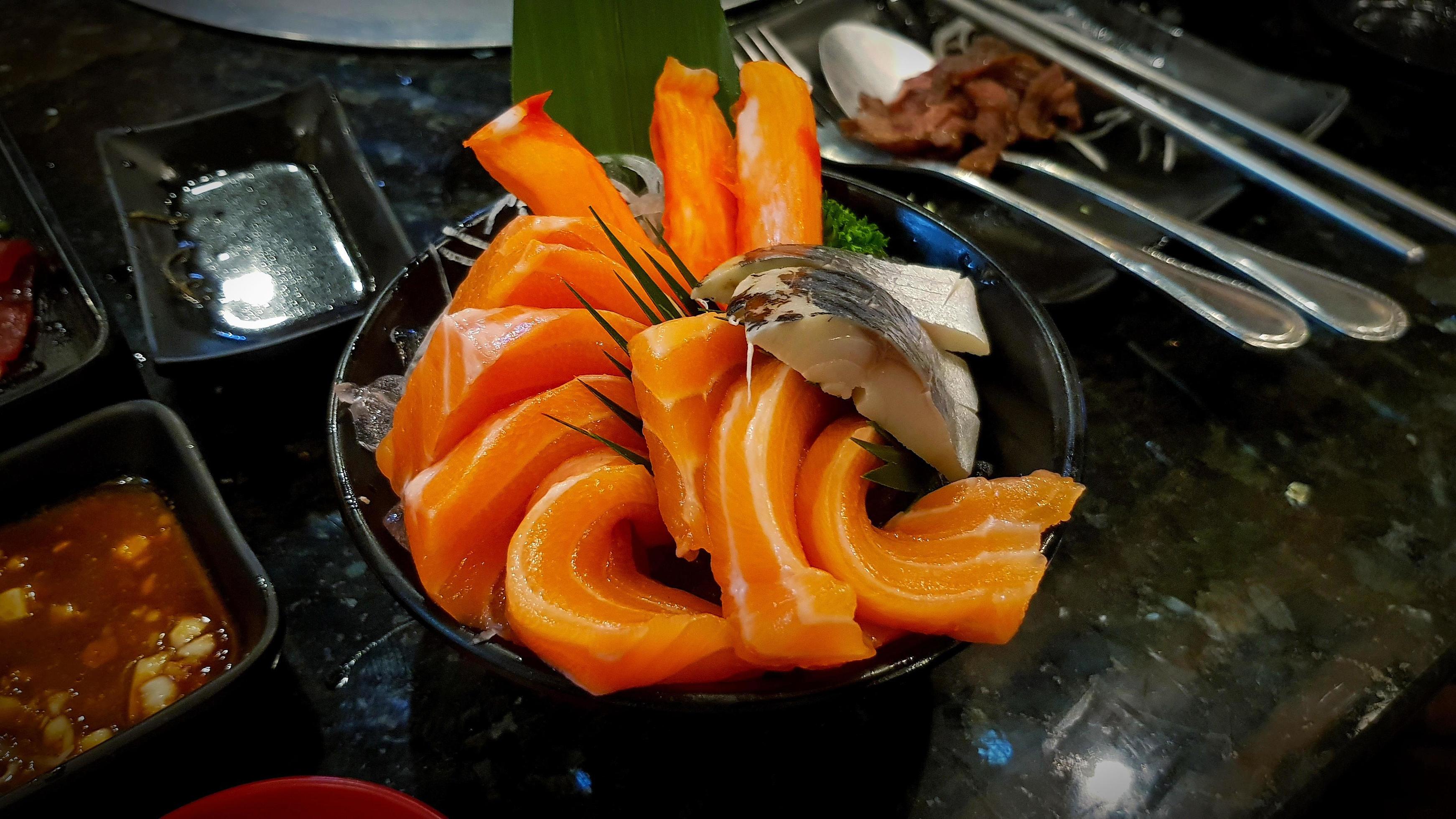 Close up fresh sliced salmon and tuna in black bowl with soy sauce on black table at Japan restaurant. Japanese food and freshness fish meal Stock Free